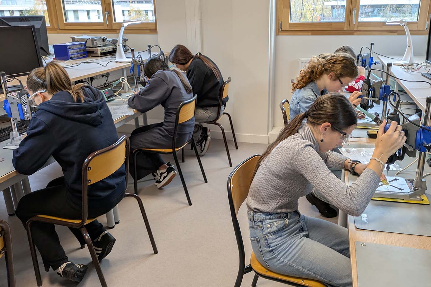 Des collégiennes font des manipulations en labo